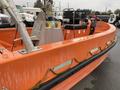 A bright orange 2008 Fassmer 20 Foot Fast Rescue boat featuring a central console with controls and a seating area visible within the boat's interior