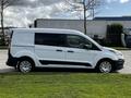 A white 2016 Ford Transit Connect van parked with a sliding side door and round wheels visible