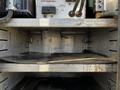 A 2018 Ford F-550 with an empty storage compartment showing metal shelves and equipment connections