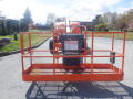 A 2008 JLG Boom Lift with an orange platform and safety railings positioned in the foreground