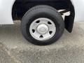 Close-up of a silver wheel with a round center cap mounted on a tire of a 2010 Ford F-250 Super Duty