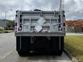 A 2017 International WorkStar 7600 truck viewed from the rear featuring a dump bed and hazard signs displayed on the truck's back