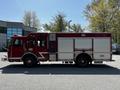 A red 2006 Emergency One Fire Truck with multiple compartments and a 911 label on the side
