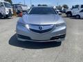 A silver 2017 Acura TLX with a distinctive front grille and sleek headlights facing forward