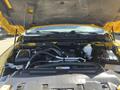 The engine compartment of a 2015 RAM 1500 showing the engine assembly with various components including hoses and a battery