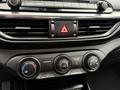 Interior controls and dashboard features of a 2021 Kia Forte including climate control knobs and audio system buttons