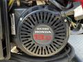 A close-up of a Honda GX390 engine with a round air filter cover labeled 13.0 in red letters