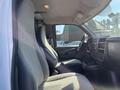 Interior of a 2013 Chevrolet Express showing the front seats and dashboard with gray upholstery and various controls