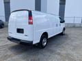 2023 GMC Savana white cargo van with rear doors and no windows on the sides