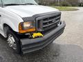 A 2000 Ford F-450 truck with a damaged front bumper and a yellow winch mounted on the front