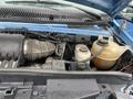 The image shows the engine compartment of a 2009 Ford Econoline with various components visible including an air intake and two fluid reservoirs