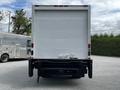 A 2018 Hino 195 box truck seen from the rear with a white cargo area and a black chassis featuring a liftgate