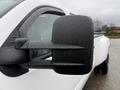 A white 2013 Chevrolet Silverado 3500HD pickup truck with a large side mirror showing droplets of water on its surface