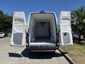 A 2019 Mercedes-Benz Sprinter van with open rear doors revealing an empty cargo area featuring a smooth floor and insulated walls