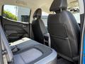Interior of a 2021 Chevrolet Colorado showcasing the rear seats with a light gray and black color scheme and a central armrest between the seats