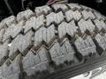 Close-up of the tread pattern on a tire of a 2014 Hino 195 showing deep grooves and uneven wear indicating usage on varied terrain