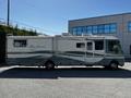 A 2000 Ford Motorhome with a gray and white exterior featuring distinct stripes and multiple rooftop air conditioning units
