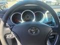 Steering wheel of a 2010 Toyota Tacoma with a visible Toyota logo and dashboard gauges in the background