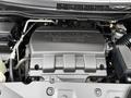 Close-up of the engine compartment of a 2014 Honda Odyssey featuring a prominent silver engine cover with the Honda logo and various engine components