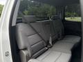 The interior of a 2016 GMC Sierra 1500 showing the back seat with gray fabric upholstery and seat belts attached to the seats