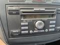 Close-up of the dashboard of a 2010 Ford Transit Connect showing the stereo system with buttons for CD, AUX, volume, and clock display