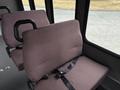 A brown upholstered seat with a black safety belt inside a 2014 Ford E-350 van
