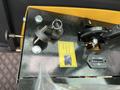 Close-up view of the control panel of a 2024 AGT Industrial Yellow H13R Mini Excavator with keys and switches visible