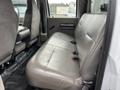 A gray leather bench seat in the back of a 2010 Ford F-250 SD with two seat belts visible