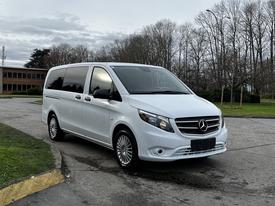 A white 2018 Mercedes-Benz Metris van is parked with its front angled towards the viewer showcasing its sleek design and distinctive grille