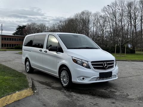 A white 2018 Mercedes-Benz Metris van is parked with its front angled towards the viewer showcasing its sleek design and distinctive grille