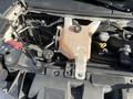 Engine compartment of a 2018 Chevrolet Express featuring a coolant reservoir and various hoses and caps