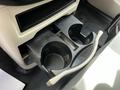 A plastic cup holder with two compartments located in a vehicle's console