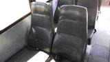 Interior seats of a 2014 Freightliner Thomas diesel bus featuring black upholstery and seatbelts