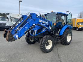2016 New Holland T475 tractor with a blue and black body and front loader attachment parked on a concrete surface