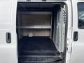 A 2015 Chevrolet Express van with open rear doors showcasing a clean, empty cargo space and metal shelving installed inside