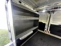 A 2017 Ford Transit van interior featuring industrial shelving units with multiple shelves designed for storage
