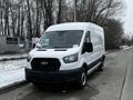 A 2021 Ford Transit van with a white exterior parked on a snowy surface with a black grille and no visible license plate