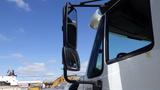 A 2015 International 7400 truck with a prominent side mirror positioned at an angle showcasing its large truck features