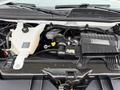 A 2014 GMC Savana engine compartment showing various components including the coolant reservoir battery and engine cover