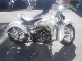 A vintage 1947 Harley-Davidson WL motorcycle featuring a classic design with a white frame and chrome details