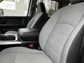 Interior view of a 2022 RAM 1500 Classic with grey fabric seats and a central console featuring storage and control elements