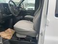 A 2012 Chevrolet Express van interior showing a driver's seat with gray upholstery and a steering wheel visible