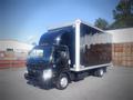 A 2013 Mitsubishi Fuso FE 160 box truck with a black exterior and a large cargo compartment in the back