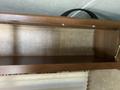A wooden shelf inside a 2016 Jayco 265RLSW recreational vehicle with a flat surface and metal support brackets attached on the side