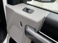 Interior detail of a 2020 Ford F-350 door panel showing a speaker grille power window controls and a textured armrest