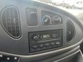 Dashboard of a 2004 Ford Econoline featuring air conditioning controls radio with digital display and various knobs and buttons