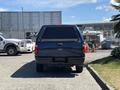 A 2014 Ford F-250 Super Duty truck viewed from the rear with a black exterior and a covered bed