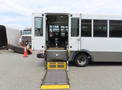 A 2020 Chevrolet Express with an extended ramp for accessibility enters through the rear doors showcasing the interior seating area