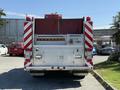 A 1991 International 4600 fire truck with a silver rear compartment featuring red and white stripes and warning lights