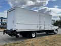 A white 2006 Hino 268 box truck with a flatbed and a side door is parked on a paved surface